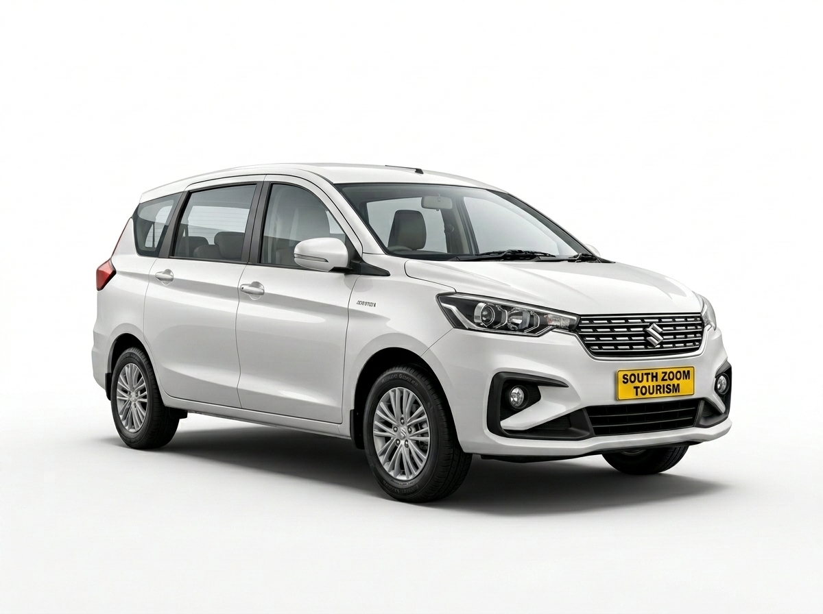 White Maruti Ertiga small SUV taxi with KA registered yellow board and SZT sticker